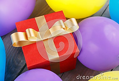 Red gift box with gold ribbon in balloons Stock Photo