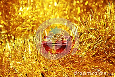 Red gift box on golden fluffy decorations Stock Photo