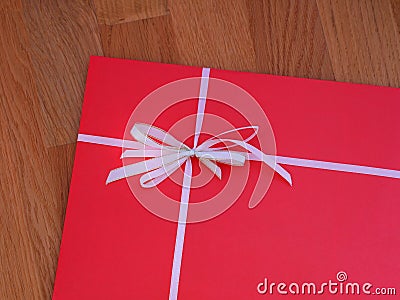 A red gift with white bow on a wooden background Stock Photo