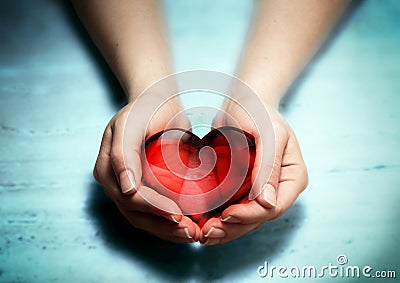 Red glass heart in woman hands Stock Photo