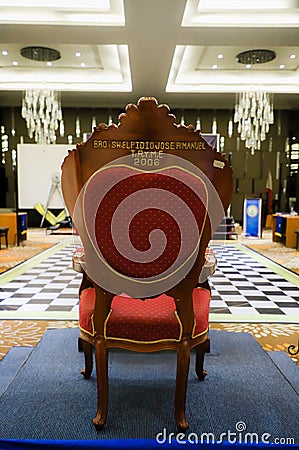 a red and gold chair sitting in a room with blue carpet Editorial Stock Photo