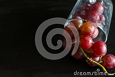 Red grapes, large bunch of fruits, fresh and tasty simple food on a dark background in a fancy minimal composition Stock Photo