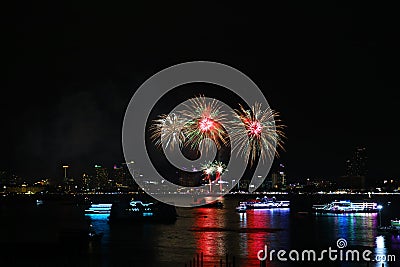 red green gold fireworks on beach and reflection color on water surface Stock Photo