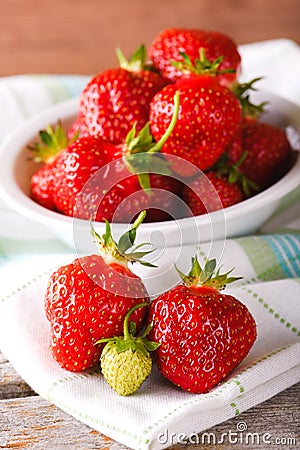 Red and green strawberries on towel in front of bowl Stock Photo