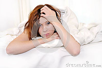 Red hair woman on bed waking up with hangover and headache Stock Photo