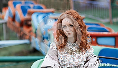 Red-haired girl in an amusement park Stock Photo