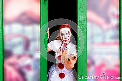 Red haired girl with makeup on her face in the style of a scary clown. Stock Photo