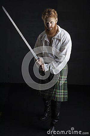 Red-haired Scotsman posing with a sword Stock Photo