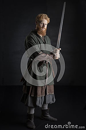 Red-haired Viking posing with weapons Stock Photo