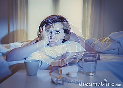 Red haired woman sick in bed with medicine Stock Photo