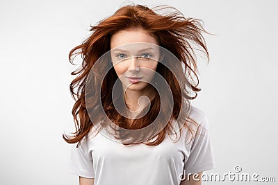 Red-Haired Young Woman With Loose Hair Posing Over White Background Stock Photo