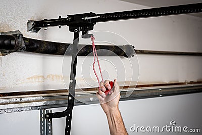 Man pulls red quick release for a garage door opener Stock Photo