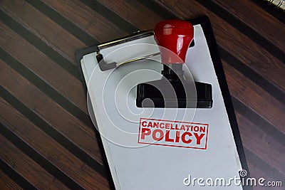 Red Handle Rubber Stamper and Cancellation Policy text isolated on wooden table Stock Photo