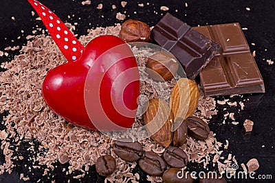 Red heart with coffee beans, chocolate, almonds and hazelnuts Stock Photo