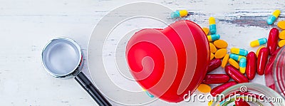 Red heart model with stethoscope and drugs Stock Photo