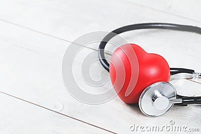 Red heart with phonendoscope on grey wood Stock Photo