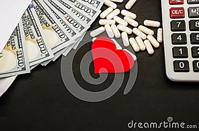 Red heart, pills, dollars in an envelope on a black background. Health concept. Stock Photo