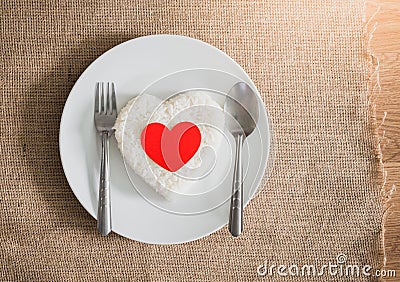 Red heart on rice heart shape on whiteplate Stock Photo