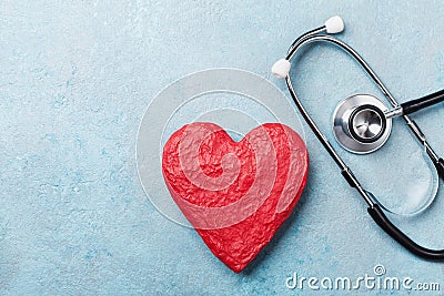 Red heart shape and medical stethoscope on blue background top view. Health care, medicare and cardiology concept. Stock Photo