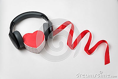Red heart shaped with stereo headphones and a red ribbon on white background. Listen to your heart. Music of Heart Stock Photo