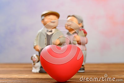 red heart and smiling elder couple on background Stock Photo