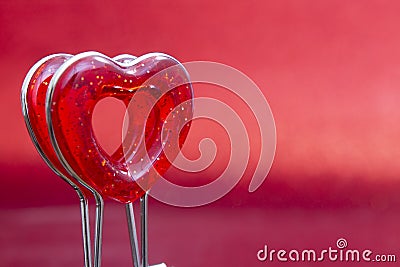 Red heart on a stand in the foreground on a red background with bokeh Stock Photo