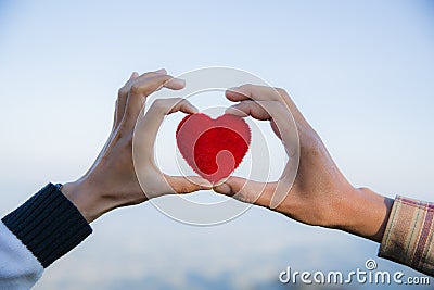 Red heart in woman and man hands, hands holding a soft heart shape, Couple love, Valentine`s Day Stock Photo