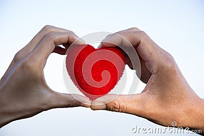 Red heart in woman and man hands, hands holding a soft heart shape, Couple love, Valentine`s Day Stock Photo