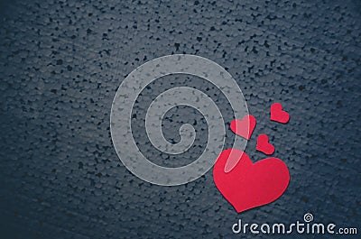 Red hearts different size on a black background - symbol of love and valentines day background. Place for writing text. Love conce Stock Photo