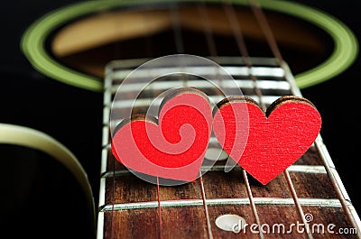 Red hearts on the strings of a guitar. Hearts are a symbol of love. Valentine`s Day Stock Photo