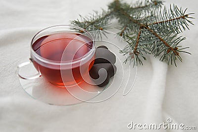 Red hot aromatic tea made from forest fruits or herbal or apples or red fruits in the glass cup on a white blanket. Stock Photo