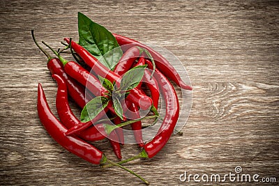 Red hot chili peppers and basil leaves on wooden Stock Photo