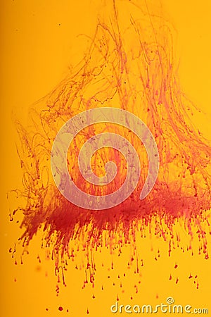 Red ink dissolving over orange Stock Photo