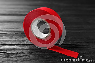 Red insulating tape on black wooden table Stock Photo