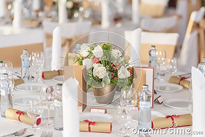 Red and ivory floral arrangement prepared for reception, wedding table with candle and setting, winter concept Stock Photo