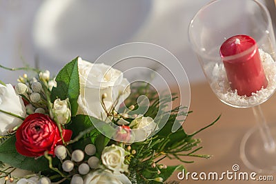 Red and ivory floral arrangement prepared for reception, wedding table with candle and setting, winter concept Stock Photo