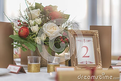 Red and ivory floral arrangement prepared for reception, wedding table with candle and setting, winter concept Stock Photo