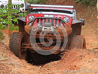 Red jeep attempts to climb a big hill off road Editorial Stock Photo