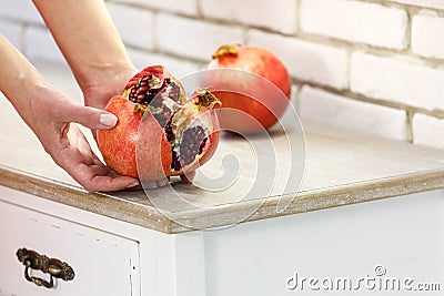 Red juicy ripe pomegranate in female hands. Fault. Stock Photo