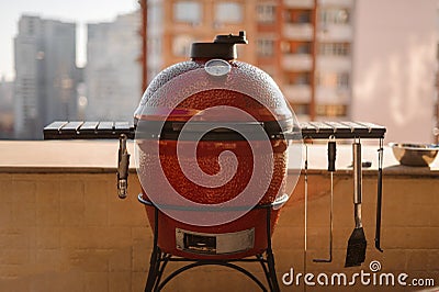 Red kettle barbecue grill closed and covered with lid and equipped with cooking tools cooking a dish Stock Photo