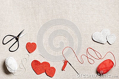 Red knit hearts for valentines day or wedding, hand make crochet heart, hook, yarn on sackcloth background, handcraft Stock Photo