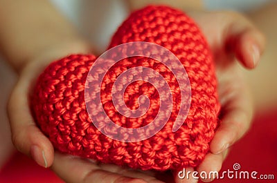 Red knitted heart in in children`s hands Stock Photo