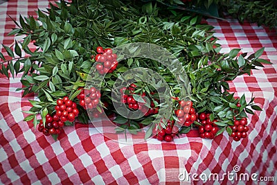 Red Kokina Flower Butcher`s Broom Christmas arrangements with green leaves, red berries. Shepherdia argentea, Cowberry berry Stock Photo