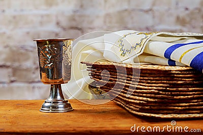 Red kosher wine with a white plate of matzah or matza and a Passover Haggadah on a vintage wood background Stock Photo