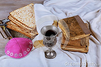 Red kosher wine with a white plate of matzah or matza and a Passover Haggadah on a vintage wood background Stock Photo