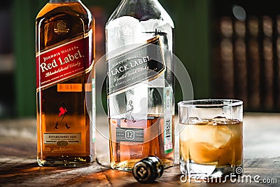 Red label and Black label whiskey bottles and glass with ice cub Editorial Stock Photo