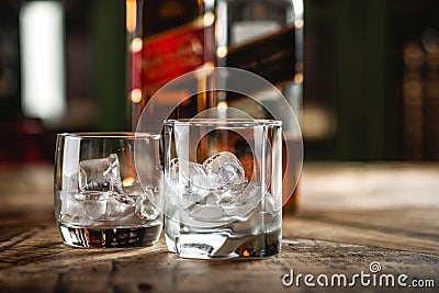 Red label and Black label whiskey bottles and glass with ice cub Editorial Stock Photo