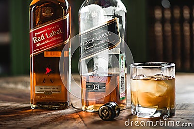 Red label and Black label whiskey bottles and glass with ice cub Editorial Stock Photo