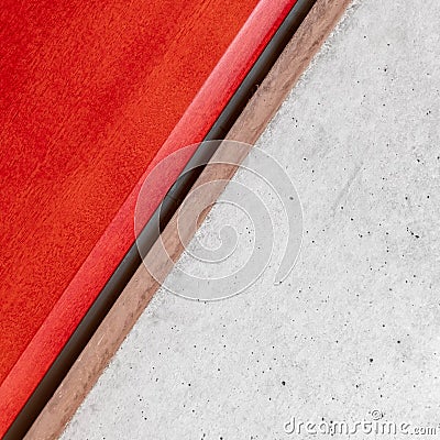 Red lacquered wood and raw cement surface close up background. Stock Photo