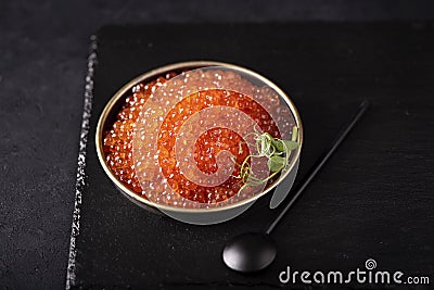 red large salted caviar in a small black plate Stock Photo